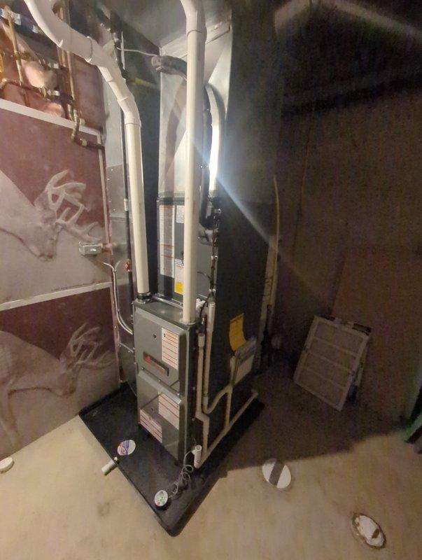 Completed full furnace and air conditioning system installation in basement utility room. Installed new furnace unit on condensate drain pan with proper PVC venting for exhaust and intake, connected copper refrigerant lines to outdoor condenser, and integrated ductwork to existing air distribution system. All equipment mounted securely per manufacturer specifications, system tested and activated successfully.