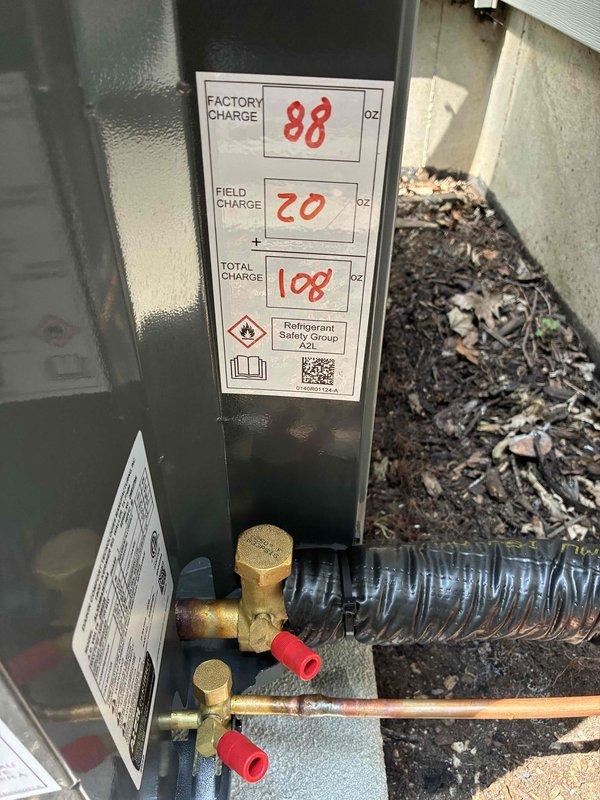 Completed full air conditioning system replacement at residential property. New outdoor condensing unit installed on existing concrete pad against exterior wall, with proper refrigerant line connections to indoor air handler. System charged with total of 108 oz of refrigerant (88 oz factory charge plus 20 oz field charge), electrical disconnect properly mounted, and all connections tested and verified operational.