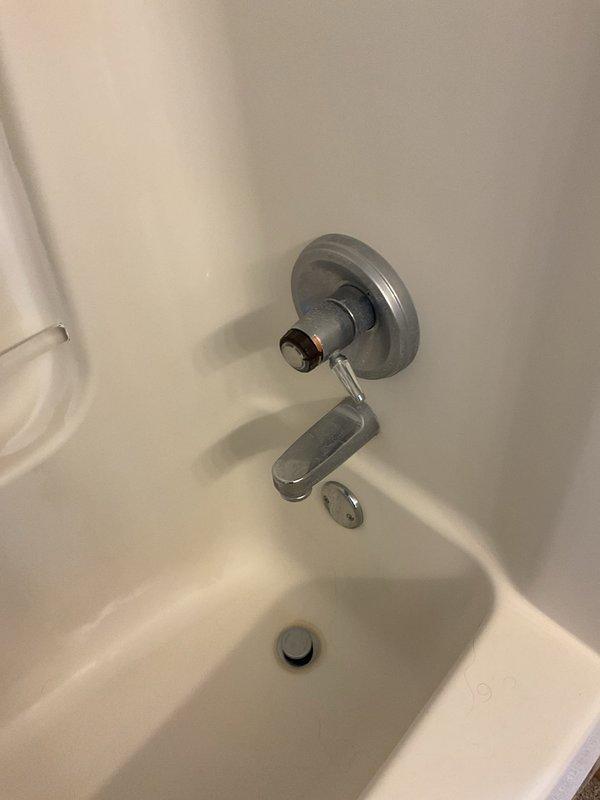 Responded to service call for leaky kitchen faucet and bathtub faucet with temperature control issues in a thirty-year-old residence. Inspected kitchen double-basin sink with chrome center-mount faucet and side spray attachment, identifying source of leak and performing necessary repairs to restore proper function. Addressed bathtub single-handle wall-mount faucet assembly where spout showed improper installation with visible gap between fixture and wall; repositioned and secured spout to eliminate leak potential and adjusted temperature control mechanism to ensure consistent water temperature regulation. Documented conditions with photographs for service records.