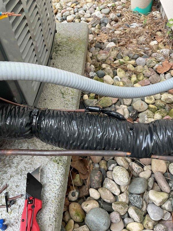 Responded to no-cool condition on 4-year-old EnergiAir system. Upon arrival, inspected outdoor condenser unit and associated refrigerant lines. Documented existing installation showing flexible ductwork and refrigerant line set routing through landscaped area with river rock ground cover. Identified service issue, performed necessary repairs to restore cooling operation. System tested and verified operational before departure.