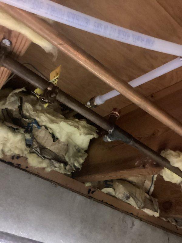 Completed water softener installation at residential property. Accessed attic space through ceiling panel to route supply and drain lines, working around existing copper and PVC plumbing infrastructure. Installed new water softener unit with proper connections to main water supply line. Secured all piping, verified system operation, and restored ceiling access panel. Installation complete and system operational.