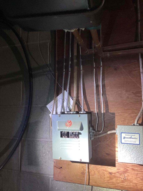 Conducted an on-site estimate for complete furnace and air conditioning system replacement in a residential property. Assessed the existing mechanical room infrastructure, including electrical panel capacity, available space for equipment installation, and current ductwork configuration in the unfinished basement area. Documented the installation environment with detailed photographs showing the electrical service panel, exposed wall framing, and existing flexible ductwork routing to determine equipment specifications and installation requirements for the proposed HVAC system upgrade.