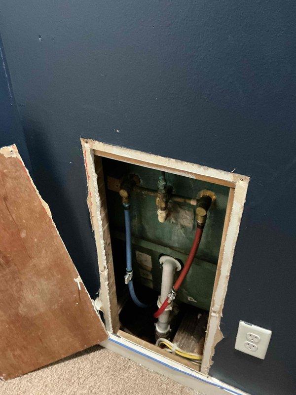 Responded to service call for stripped cold water handle screw causing faucet to stick in on/off positions. Created wall access opening to expose supply line connections and plumbing infrastructure behind affected fixture. Inspected brass fittings, flexible supply lines (hot and cold), and drainage connections within wall cavity. Documented existing plumbing configuration including PEX tubing, shutoff valves, and trap assembly for historic property. Access point prepared for faucet handle replacement or complete fixture upgrade as needed.