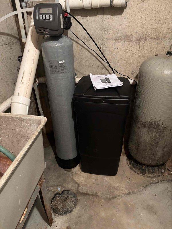 Completed installation of new water softener system with electronic control head and brine tank in utility area. Replaced existing 50-gallon electric water heater with new unit, connecting all supply and drain lines. Installed 1.6 gallon per flush tall round toilet in downstairs bathroom at no additional charge. Investigated persistent drain issue as requested by client; drain remains non-functional and will require further assessment to identify underlying blockage or system defect. All new plumbing equipment tested and operational except for the problematic drain line. Job duration was 4 hours.