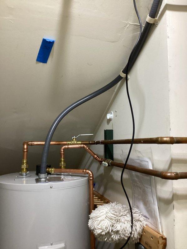 Completed installation of a 50-gallon electric tall Bradford White water heater in utility closet. Connected copper supply lines with brass fittings and valves, secured electrical conduit to wall with cable ties, and verified all plumbing connections for proper operation. Unit installed per manufacturer specifications with all required safety labels visible and accessible.