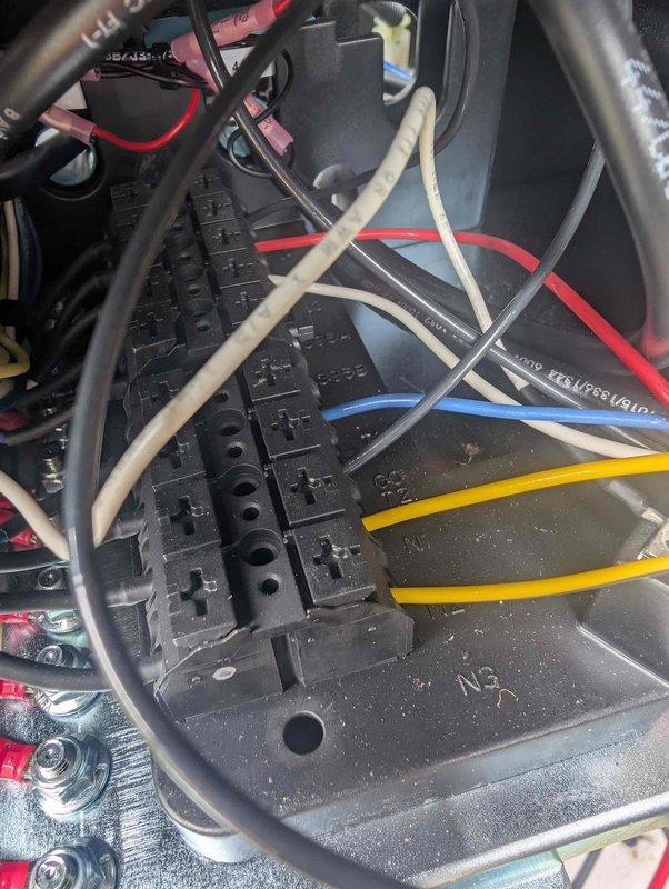 Responded to generator battery charging alert. Technician inspected electrical connections and control panel wiring to diagnose charging system failure. Examined terminal blocks, wire connections, and control module components. Documented existing conditions with photos showing terminal block assembly with multiple colored wire connections and control panel interior containing electrical module with fuse protection and various circuit connections. Investigation revealed potential issues with battery charging circuit requiring further evaluation upon return visit.