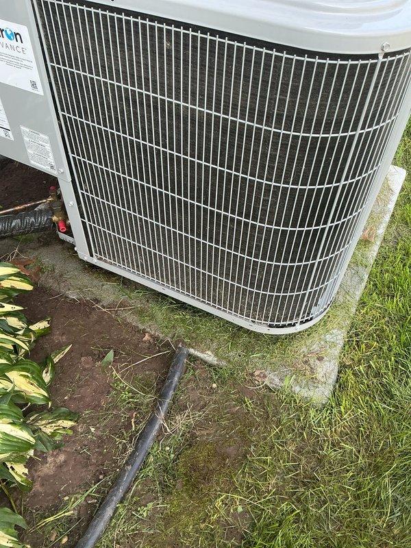 # Annual Cooling Maintenance - Carrier Condensing Unit

Completed comprehensive annual cooling maintenance on a 2018 Carrier outdoor condensing unit, model WT 03-2031. Performed visual inspection of the cylindrical condenser unit with vertical fin coil configuration, confirming proper installation on concrete pad with adequate clearance. Verified manufacturer labeling and unit identification information intact and legible.

Inspected condenser coil fins for damage, debris accumulation, and proper airflow clearance. Examined top-mounted fan guard assembly with radial wire spoke configuration for structural integrity. Checked condensate drainage line routing and confirmed proper discharge away from unit foundation. Evaluated electrical conduit and wiring connections for secure attachment and code compliance.

Assessed unit housing and cabinet condition, noting clean exterior surfaces with no visible corrosion, rust, or deterioration on metal components. Verified protective grilles and fa