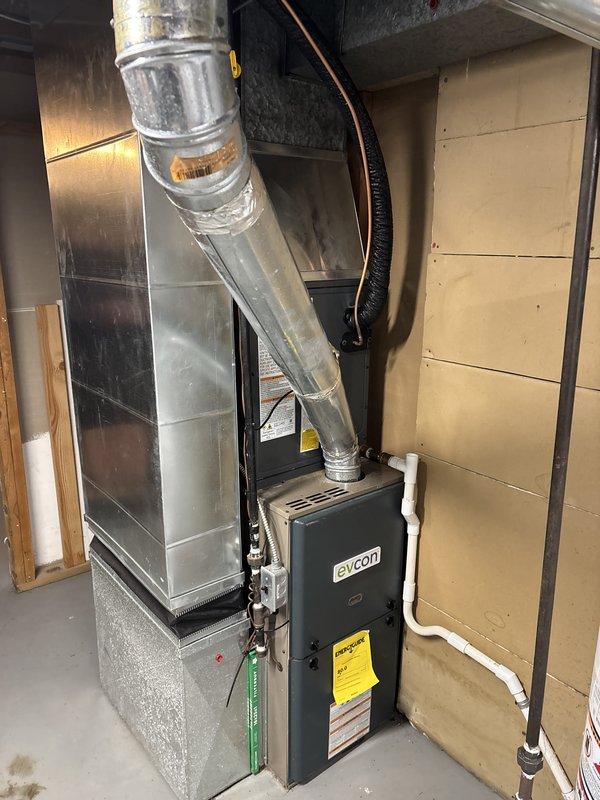 Complete HVAC system replacement performed, including installation of new air conditioning condenser unit and indoor air handler. Outdoor condenser unit positioned on concrete pad with proper gravel base for drainage and stability, with refrigerant lines and electrical connections properly installed. Indoor evcon air handler installed in basement utility area with connections to existing ductwork system, including proper integration with supply and return plenums. All electrical connections, refrigerant lines, and condensate drainage systems installed per manufacturer specifications and local code requirements. System tested and verified operational upon completion.