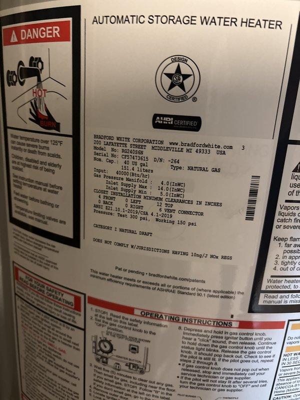 Successfully installed a 40-gallon Bradford White automatic storage natural gas water heater with 40,000 BTU/h input capacity in utility closet alcove. Connected copper water supply lines, installed proper venting with black exhaust piping, and established all necessary valve controls and connections. Unit was properly positioned against concrete block wall with all manufacturer specifications verified, safety labels intact, and operating instructions accessible for future reference.
