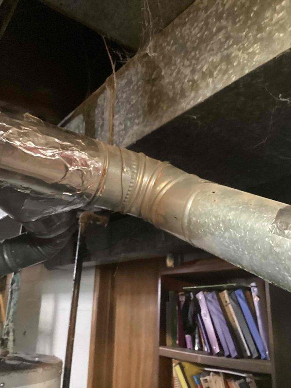 Completed annual cooling maintenance on 6-year-old Luxaire system. Performed comprehensive tune-up including inspection of ductwork, connections, and insulation integrity. Documented existing flexible duct penetration through ceiling structure and supply duct configuration in basement area showing proper insulation and condensation management on cold surfaces.