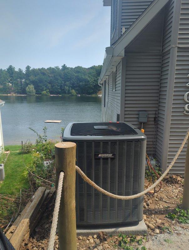 Completed full air conditioning system replacement at lakefront residential property. Installed new outdoor condenser unit on concrete pad adjacent to building exterior, establishing proper clearances and securing all electrical connections through existing conduit infrastructure. Verified system operation, refrigerant charge, and airflow parameters to manufacturer specifications upon completion.