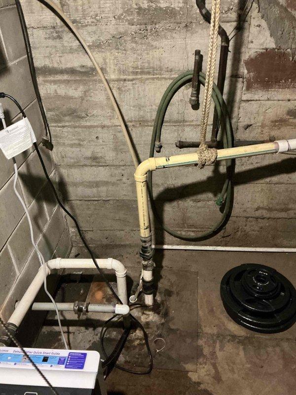 Responded to emergency sump pump failure in basement of 50-year-old residential property that had experienced flooding from laundry drain backup. Upon arrival, found existing sump pump system in severely deteriorated condition with extensive moisture damage, corrosion, and biological growth throughout the sump pit area. Assessed pump functionality, inspected drainage lines and discharge piping, and evaluated overall system condition in utility space showing signs of long-term water exposure and inadequate maintenance. Documented equipment condition and surrounding area with photographic evidence for home warranty claim processing through American Home Shield. Provided homeowner with findings and recommendations for system repair or replacement to prevent future flooding incidents.
