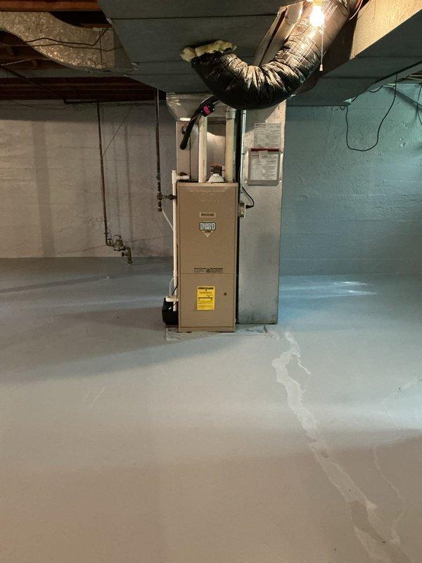 Responded to water leak complaint in basement utility area affecting 13-year-old Ecoair HVAC system. Inspected furnace and air conditioning unit to identify source of water leakage between AC and furnace components. Documented existing conditions of mechanical room including furnace unit, ductwork connections, and utility sink area with photographic evidence for diagnostic purposes.