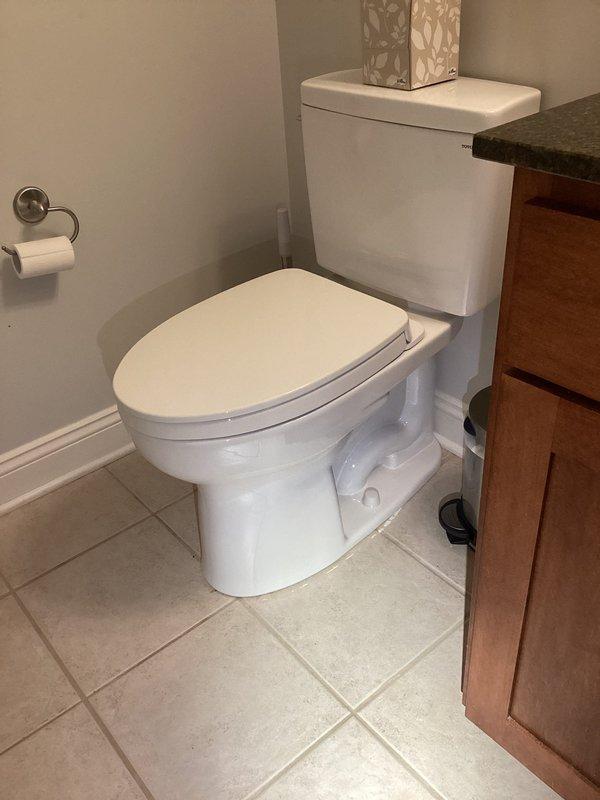 Removed existing two-piece toilet from bathroom and installed customer-supplied replacement unit. Disconnected water supply line, removed old toilet from flange, and inspected existing flange for proper condition. Installed new white porcelain two-piece toilet with standard tank and bowl configuration, ensuring proper seal at flange connection and secure mounting to floor. Reconnected water supply line to tank fill valve, tested for leaks, and verified proper flush operation and tank refill function.