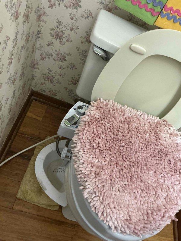 Responded to a toilet leak originating from an aftermarket bidet attachment installed on the water supply line. Inspected the bidet unit's connection points, water supply hose, and mounting hardware to identify the source of the leak. Tightened supply line connections and verified proper seal at all attachment points to resolve the issue and restore normal operation.