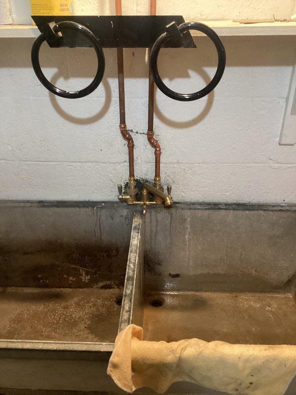 Replaced laundry tub faucet in basement utility area, removing old oxidized copper supply connections and installing new brass shutoff valves and supply lines. Rebuilt faucet assembly in upstairs full bathroom, servicing vintage-style chrome cross-handle fixtures mounted on console sink. Disassembled existing faucet components, replaced worn internal cartridges and seals, cleaned mineral deposits from valve seats, and reassembled with new hardware to restore proper water flow and eliminate leaks.