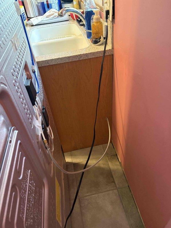 Installed new shutoff valve on copper water supply line in basement to provide dedicated water source for refrigerator icemaker. Accessed existing cold water distribution piping beneath first floor joists, cut into copper line, and installed compression-style shutoff valve with quarter-inch outlet for icemaker connection. Routed flexible water supply line from new valve location through floor structure to refrigerator location in adjacent laundry/utility area, securing line to floor joists with appropriate strapping to prevent sagging or damage. Tested valve operation and checked for leaks at all connection points to ensure proper installation and water flow to appliance.
