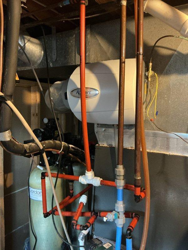 # Condensate Drain Issue Resolution

Responded to complaint of condensate dripping and water damage concerns. Upon inspection, discovered excessive moisture accumulation on copper refrigerant lines and significant frost buildup on suction line insulation, indicating potential airflow restriction or refrigerant charge issues. Examined condensate drainage system including primary drain line routing and humidifier installation. Verified proper drain pan condition and drainage pathways. Documented equipment conditions including Aprilaire humidifier integration with ductwork system and associated plumbing connections. Provided assessment findings and recommendations for resolving water intrusion issues.