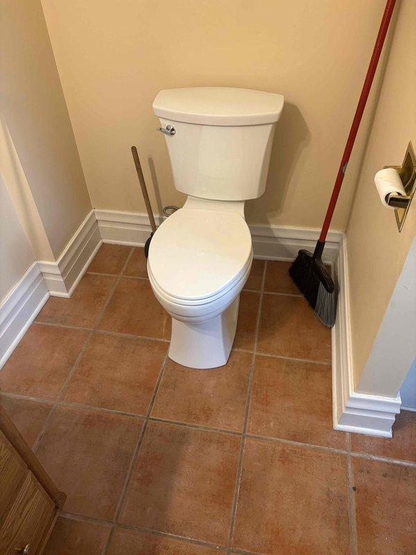 Installed new toilet in upstairs bathroom of residential property built in 1914. Removed existing fixture and set new two-piece toilet on terracotta tile flooring, connecting to existing water supply line with chrome angle stop valve. Noted significant rust corrosion on escutcheon plate at wall penetration point, though valve remains functional. Tested for proper operation and verified no leaks at connections. Installation completed successfully with all fixtures operating as intended.