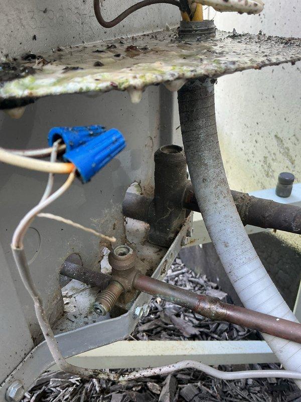 # NC-No Cool Service Call - Carrier AC Unit

Responded to no cooling complaint on 4-year-old Carrier air conditioning system. Upon arrival, found unit running but failing to produce cold air. Inspection revealed heavily corroded capacitor with significant rust and deterioration on top surface and mounting hardware. Multiple electrical connections showed signs of weathering and outdoor exposure. Interior components displayed extensive corrosion on metal brackets, pipes, and fittings, with debris accumulation at base of unit. Corroded capacitor identified as primary failure point preventing proper compressor operation. Replaced failed capacitor with new component, cleaned electrical connections, and verified proper wire terminations. Cycled system through complete cooling cycle to confirm compressor engagement and proper operation. Unit now cooling effectively with all components functioning within normal parameters.