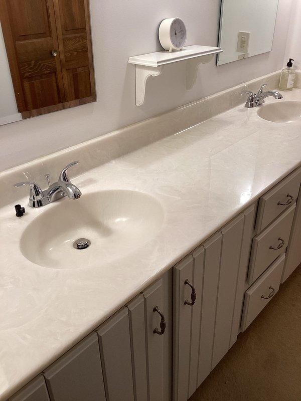 Completed installation of customer-supplied plumbing fixtures in bathroom, including two chrome faucets for double-sink vanity and shower valve with cover plate for tub/shower combination. All fixtures installed to code specifications with proper water supply connections, tested for leaks, and confirmed full operational functionality upon completion.
