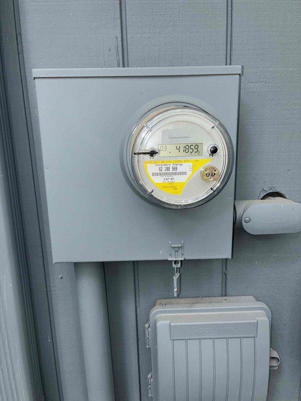 Conducted on-site evaluation for new Generac generator installation at 45-year-old single-family residence. Assessed existing electrical service configuration, including meter location, electrical panels, and available mounting space on exterior wall with blue-gray vertical siding. Documented current utility setup featuring digital electric meter, junction boxes, and conduit routing to determine optimal generator placement and transfer switch installation requirements. Photographed electrical infrastructure and potential installation area to develop comprehensive estimate for whole-home standby generator system.