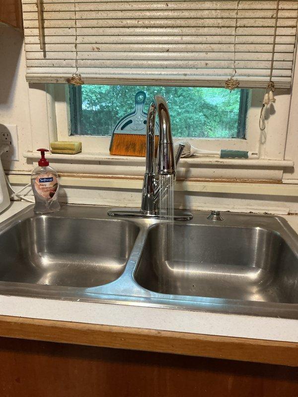 Replaced existing kitchen faucet with customer-supplied gold Delta pull-down faucet unit. Removed old chrome faucet, disconnected supply lines, and installed new Delta faucet ensuring proper mounting and seal. Connected hot and cold water supply lines, tested for leaks, and verified full range of motion on pull-down spray head. In bathroom, repaired bathtub drain stopper assembly to restore proper water blocking function. Disassembled stopper mechanism, cleaned components, adjusted linkage, and reassembled to ensure reliable seal. Tested both kitchen faucet operation and tub stopper functionality before completion. All work performed to manufacturer specifications with no leaks detected.