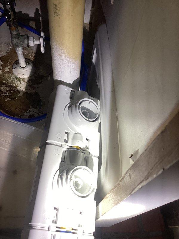 Responded to plumbing leak call for under-sink filtration system. Upon inspection, located white cylindrical filtration unit with dual inspection ports mounted in utility area beneath kitchen sink. Assessed condition of unit, associated PVC piping, fittings, and mounting hardware for source of leak. Documented existing filtration system configuration and connections. Photographed installation for warranty documentation purposes as property is covered under consumer home protection plan. Discussed repair versus replacement options with homeowner based on unit condition and age. Provided professional recommendations for addressing leak issue and ensuring proper system operation.
