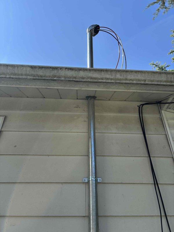 Completed 100-amp electrical service upgrade with meter relocation on residential property. Coordinated utility disconnect and reconnect, obtained electrical permit BR-ELEC-2026-1055, and installed new galvanized metal conduit along exterior wall from foundation to roofline with proper mounting brackets. Excavated trench along building foundation to route underground service conductors, relocated meter base, and scheduled required electrical inspection.