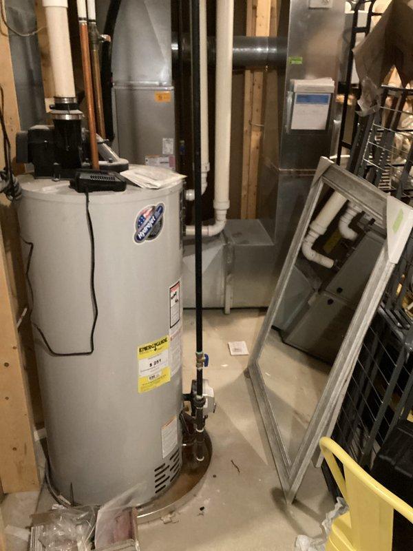 Responded to water heater emergency where utility company had shut off gas supply due to safety concerns regarding carbon monoxide venting and small leak detection. Upon arrival, inspected 9-year-old residential water heater that had been red-tagged by utility for improper venting conditions. Conducted thorough assessment of venting system, examining flue pipe connections, draft hood, and exhaust pathway for proper combustion air flow and carbon monoxide discharge. Identified compromised venting components and minor leak at tank connections. Documented existing conditions with photographs showing water heater installation, surrounding mechanical equipment, and HVAC ductwork configuration in basement mechanical room. Verified no active gas odor present and confirmed CO alarms were not activated at time of inspection. Evaluated unit's operational history noting decreased efficiency prior to shutdown. Provided homeowner with assessment findings and recommended corrective actions required 