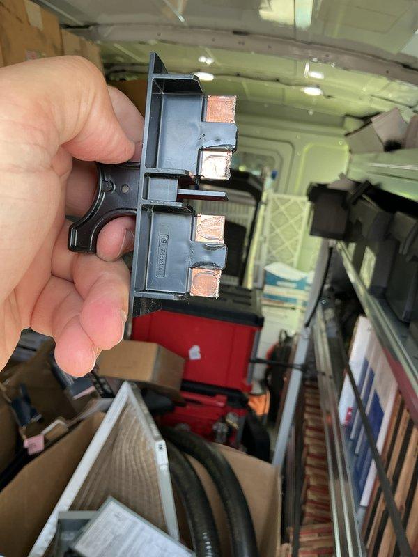Completed quoted repair work and documented electrical disconnect component requiring installation. Photographed fuse holder assembly with three copper terminals in preparation for technician to return and complete disconnect installation. Work order remains open pending final installation.