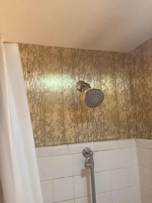 Conducted on-site assessment for tub-shower replacement estimate. Documented existing bathroom conditions, including severe water damage and deterioration to upper shower wall surfaces with extensive peeling and flaking, while lower subway tile section and fixtures remain intact. Captured comprehensive photos of current plumbing fixtures, shower configuration, and overall bathroom layout to provide accurate project scope and material requirements for complete tub-shower installation quote.