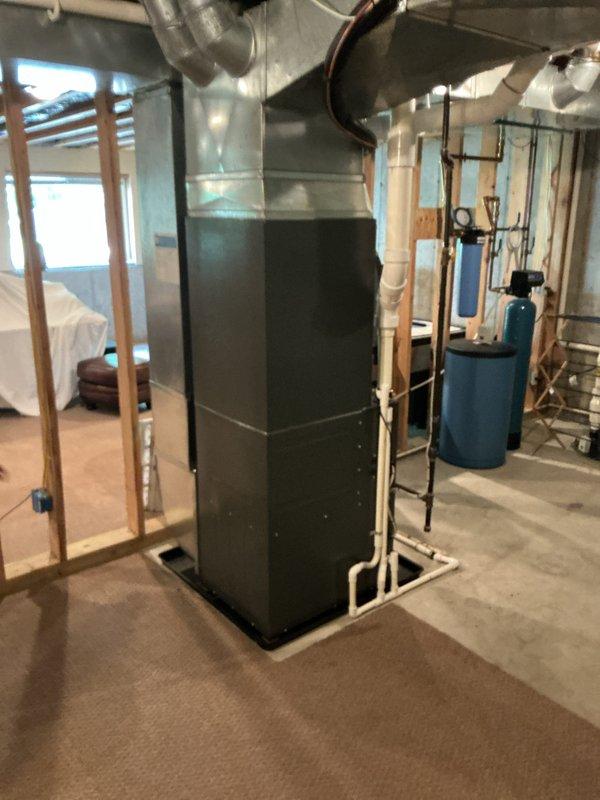 Completed full residential HVAC system installation including new furnace and air conditioning condenser unit. Installed furnace in basement mechanical room with metallic ductwork plenum and proper duct connections, positioned outdoor condensing unit on mulch bed with appropriate refrigerant line routing through building exterior secured with wall-mounted brackets. All equipment installed per manufacturer specifications with proper drainage considerations and system startup completed successfully.
