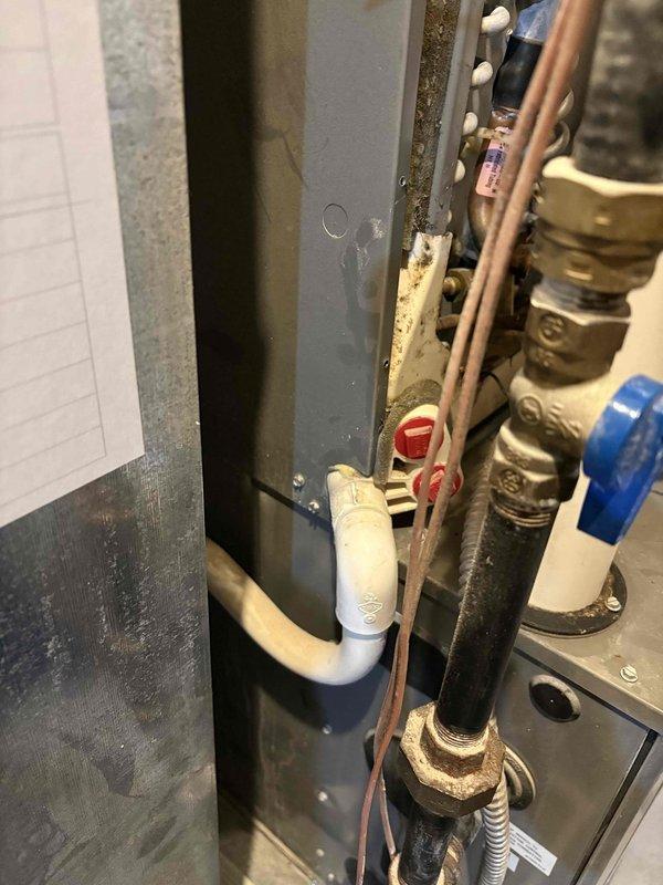 Responded to water leak call involving furnace condensate drainage issue. Upon inspection, identified water accumulation originating from the HVAC condenser system. Examined evaporator coil assembly and associated condensate drain lines in the mechanical room. Inspected PVC drainage piping, copper refrigerant lines, and shut-off valves for proper operation and potential leak sources. Verified heating system operational status and documented plumbing connections including water supply lines and drainage components. Photographed evaporator coil configuration and mechanical room piping arrangement for service records. System restored to proper operation with condensate drainage functioning correctly.