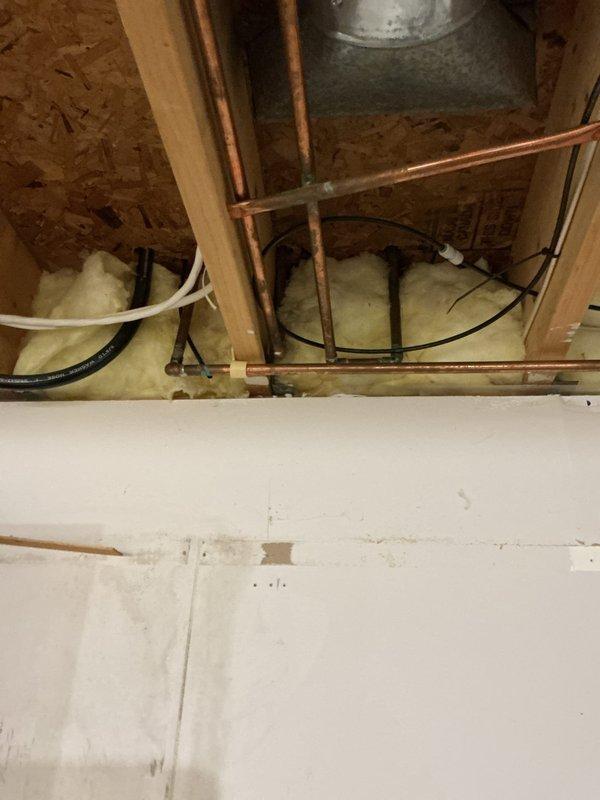 Responded to service call for multiple plumbing issues including water line leaks under kitchen sink, sewage ejection pump concerns, and toilet flushing problems. Inspected exposed plumbing system in crawl space area, examining copper water supply lines, drainage components, and HVAC connections. Assessed condition of piping showing age-related discoloration and verified proper installation of insulation around plumbing penetrations. Evaluated sewage ejection pump operation and associated discharge piping. Inspected toilet in bathroom for flushing mechanism issues, checked tank components, fill valve, and flapper assembly for proper operation. Documented all findings with photographs for service records.