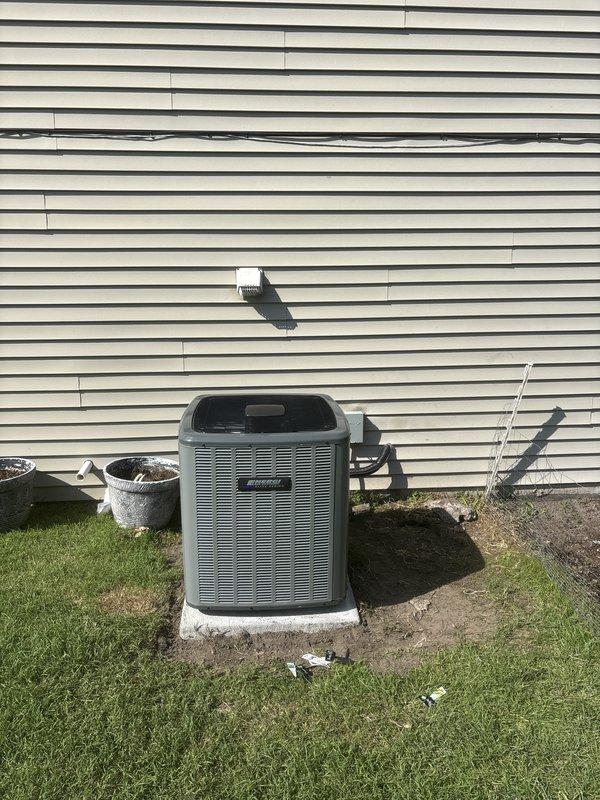 Completed same-day installation of complete HVAC system including indoor furnace unit and outdoor air conditioning condenser. Indoor unit installed in basement/utility room with proper PVC venting system, gas line connection with shutoff valve, and integrated ductwork with metallic plenum transition. Outdoor condenser unit positioned on concrete pad against building exterior with appropriate clearances, electrical disconnect box mounted on siding, and refrigerant lines properly connected between indoor and outdoor components.