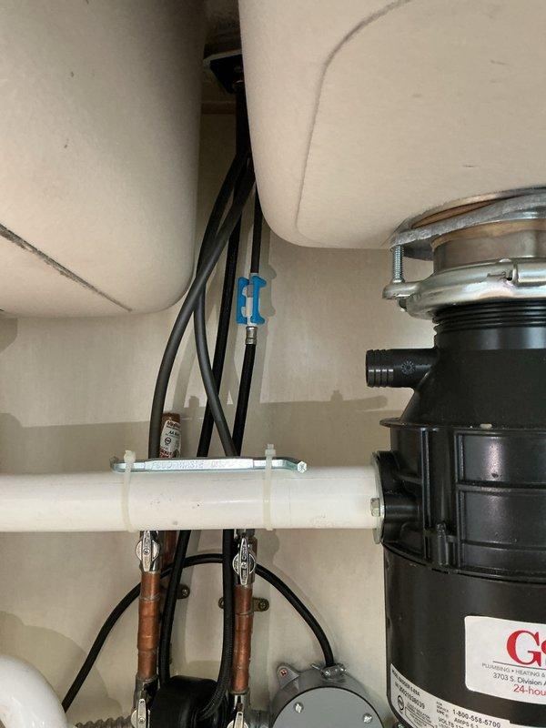 Responded to plumbing leak in kitchen sink area. Upon inspection, identified leak source at sink drain connections and addressed water intrusion issue. Inspected garbage disposal mounting assembly, drain piping, and supply line connections under double-basin stainless steel sink. Tightened mounting hardware, verified proper seal at disposal unit connection, and confirmed all PVC drain lines and copper supply lines were secure with no active leaks. Additionally, installed new faucet fixture in laundry room as requested. Tested both kitchen and laundry installations for proper operation and verified no water leaks present upon completion.
