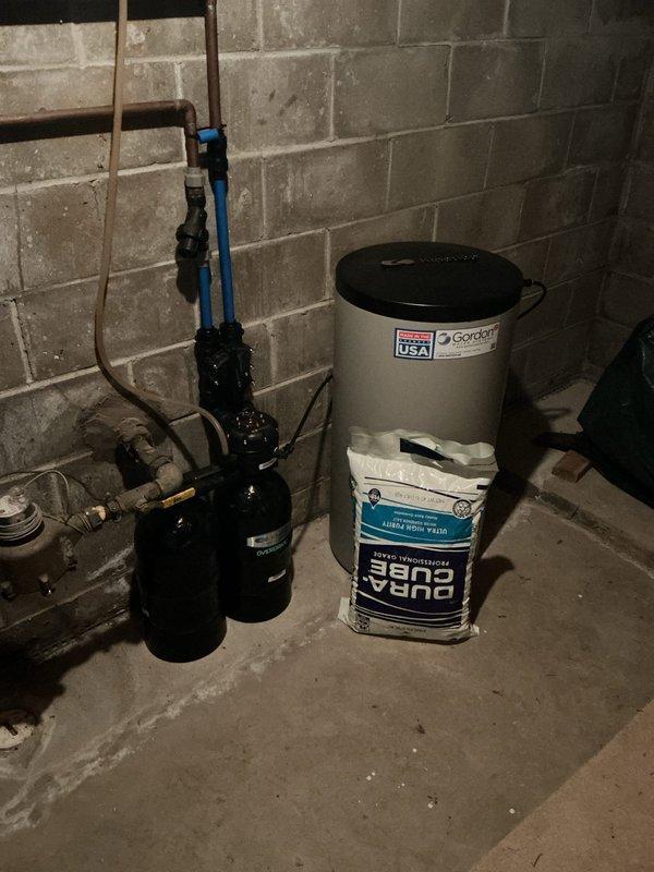 Completed annual cooling maintenance on EnergiAir system model WT 03-2034. Performed standard tune-up procedures including inspection of refrigerant levels, electrical connections, and operational components. Documentation photos captured basement utility area showing water heater, plumbing connections, sump pump system, and water softener equipment for service records.