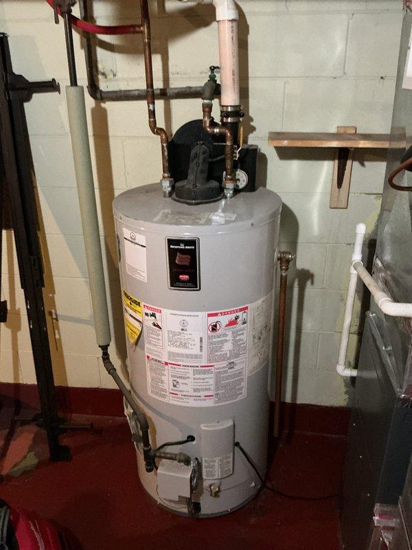 Responded to emergency call for water heater making loud rattling noise described as sounding like racks rolling around inside the unit. Upon arrival, inspected approximately 10-year-old Bradford White residential water heater. Assessed unit condition and determined noise was indicative of sediment buildup and potential tank deterioration consistent with age of equipment. Documented existing installation including copper supply lines, expansion tank, and circulator pump configuration. Photographed unit showing water staining on floor near base, indicating possible minor leakage. Given age of unit and severity of symptoms, recommended replacement rather than repair due to imminent failure risk and cost-effectiveness.