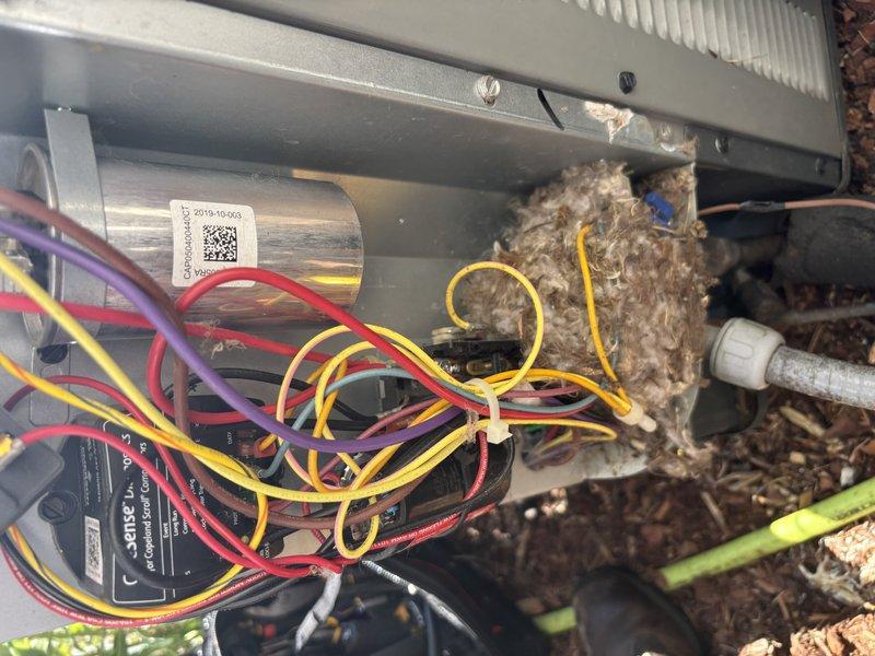 Completed annual cooling maintenance on 6-year-old EnergiAir heat pump system. Performed electrical diagnostics using digital multimeter to test capacitor function and verify proper voltage readings at all terminals. Removed significant accumulation of leaves, organic debris, and dirt from internal components and around capacitor assembly to restore proper airflow and prevent potential electrical issues. Inspected all wire connections including red, yellow, purple, and orange leads for secure termination and signs of wear. Verified system operation and documented equipment condition with photos for service records.
