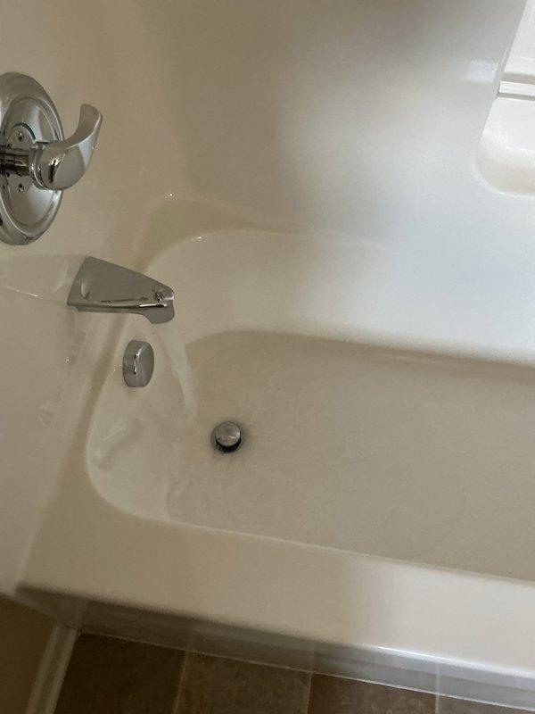 Responded to service call for non-functioning garbage disposal and slow drainage in upstairs sink and bathtub. Upon inspection, assessed bathroom plumbing fixtures including bathtub drain assembly with chrome stopper control mechanism and toilet tank components. Documented existing conditions of bathroom fixtures and drainage system to identify source of slow drain issue affecting upstairs plumbing.