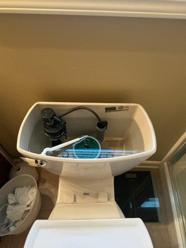 Responded to service call for non-functioning garbage disposal and slow drainage in upstairs sink and bathtub. Upon inspection, assessed bathroom plumbing fixtures including bathtub drain assembly with chrome stopper control mechanism and toilet tank components. Documented existing conditions of bathroom fixtures and drainage system to identify source of slow drain issue affecting upstairs plumbing.