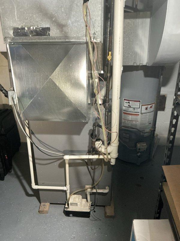 Responded to a no-cooling condition on a 19-year-old Lennox air conditioning system that had been recharged the previous day but failed again within 24 hours. Conducted comprehensive system evaluation and documented equipment condition with photos of the furnace/air handler unit and surrounding mechanical installation. Diagnosed likely refrigerant leak causing repeated loss of cooling capacity and provided estimate for necessary repairs to restore proper system operation.