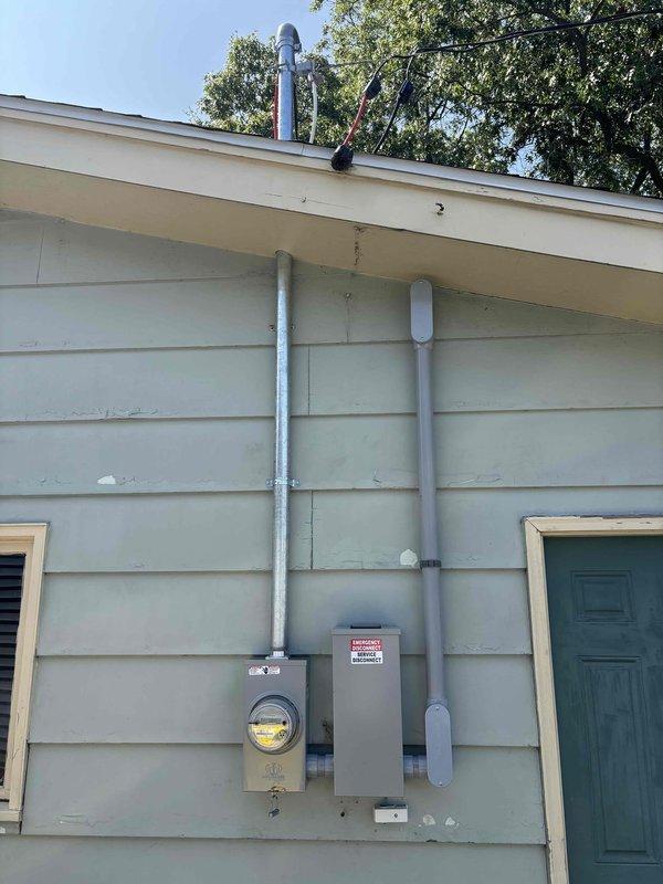 Completed 200-amp electrical service upgrade on residential property. Coordinated utility disconnect and reconnect with power company, obtained electrical permit, and scheduled required inspections. Installed new meter base, service disconnect panel, and exterior conduit runs on building exterior with light-colored lap siding. All electrical components properly mounted and secured to exterior wall with appropriate hardware and weatherproof connections. Power restoration confirmed following successful completion of work and inspection approval.