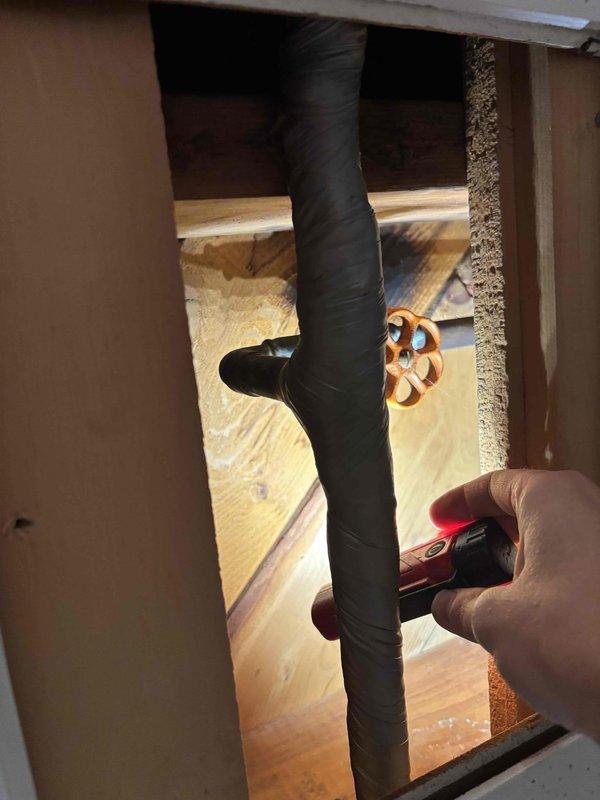 Completed annual cooling maintenance on 25-year-old Trane system. Performed comprehensive tune-up inspection including refrigerant line assessment in attic space. Inspected insulated suction line and associated plumbing infrastructure, noting aged valve assembly with significant corrosion and oxidation on handle and body. Documented condition of copper piping showing mineral deposits and patina formation, as well as galvanized piping with surface oxidation. Verified best contact number on file. System operational upon completion. Photographic documentation captured for service records.