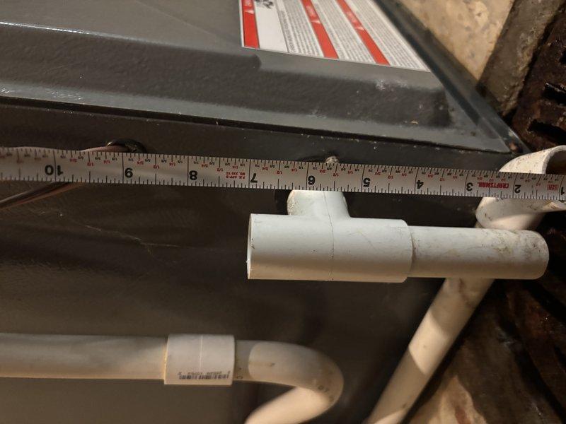 Responded to service call for water leaking around furnace with water accumulation on floor. Upon inspection, identified condensate drain issue from HVAC system. AC unit confirmed operational and cooling home effectively. Measured and assessed PVC condensate drain line configuration, including T-joints and drainage routing in mechanical area. Inspected basement utility area including laundry room proximity to HVAC equipment to determine water source and flow pattern. Addressed drainage concern to prevent further water accumulation around furnace area.