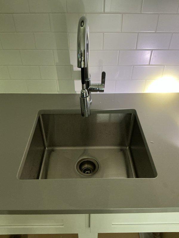 Responded to plumbing maintenance call for basement bar sink and secondary bathroom shower in eight-year-old residence. Inspected both fixtures and found worn chrome finishes with water damage and mineral deposits on bathroom tub/shower valve trim and spout. Assessed kitchen bar sink installation featuring undermount basin with pull-down faucet, confirming proper operation and drainage. Serviced both locations during single appointment as requested, addressing ten-day-old issues while verifying remainder of home's plumbing systems remained unaffected.