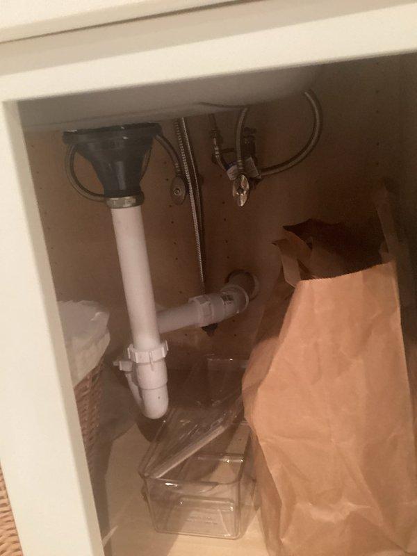 Completed faucet installation and addressed secondary faucet issue that had been present for approximately one week. Inspected under-sink plumbing configuration, which included white PVC P-trap assembly in good condition with proper drainage connections to wall outlet. Verified flexible water supply lines were properly secured and functional. Installed chrome two-handle faucet on granite countertop with stainless steel undermount sink basin. Tested water flow, checked for leaks at all connection points, and confirmed proper operation of both hot and cold water controls. All plumbing components functioning correctly upon completion.