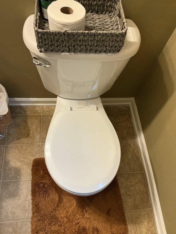Responded to report of water leaking at base of toilet in residential bathroom. Upon arrival, inspected affected fixture and surrounding area for source of leak. Documented existing conditions with photographs showing standard two-piece white porcelain toilet on tile flooring with visible moisture concerns at base. Assessed wax ring seal integrity and flange connection as probable failure points given age of 19-year-old home and reported ongoing toilet issues. Discussed replacement options for both bathroom fixtures per homeowner request due to chronic performance problems with existing toilets. Provided assessment and recommendations for complete toilet replacement to resolve leaking issue and prevent further water damage to flooring and subfloor.