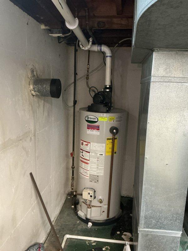 Completed rental inspection of residential heating and domestic hot water systems. Inspected and documented A.O. Smith water heater and furnace unit in basement mechanical room, verifying proper operation and safety compliance. Photographed equipment conditions, noting moisture staining on basement walls and ceiling area that may require property owner attention for potential water intrusion issues.